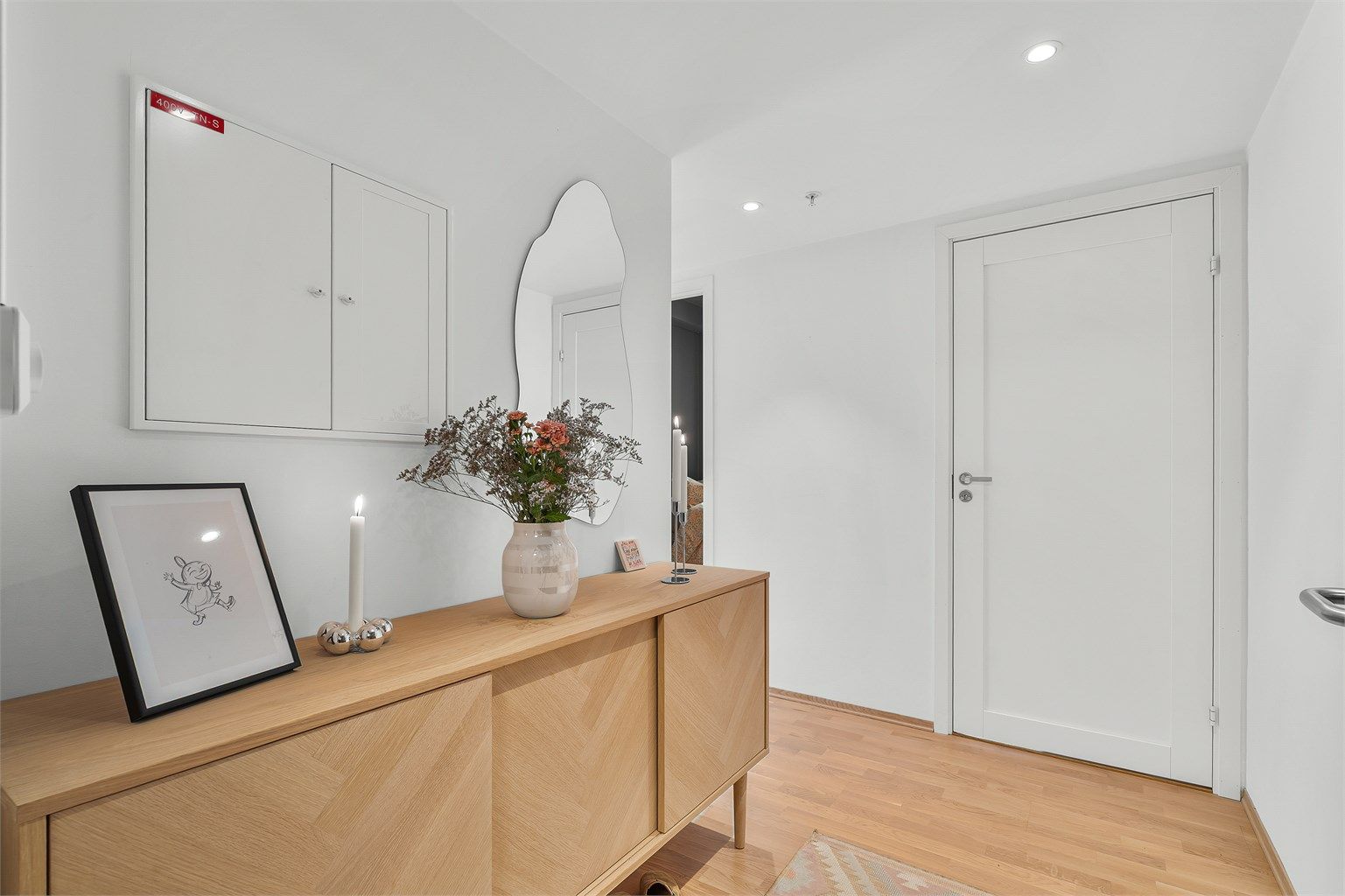 Entré med parkett på gulv og plass til oppbevaringsmøbler.