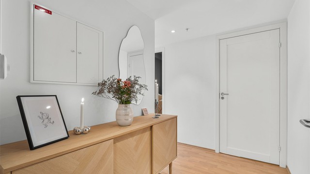 Entré med parkett på gulv og plass til oppbevaringsmøbler.