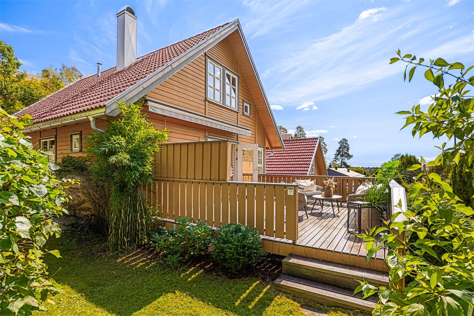 Terrasse fra stuen har trapp ned til hagen og gjør det enkelt for lek i hagen for barna.