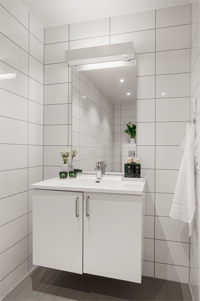 Dusjbad/wc - Hvit glatt innredning med helstøpt servant med underskap. Speil med belysning og stikkontakt.