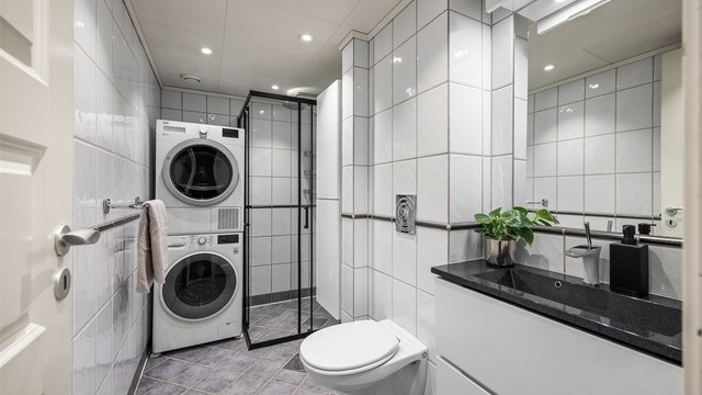 Baderommet er utstyrt med vegghengt toalett, servantmøbel og downlights i himlingen.
