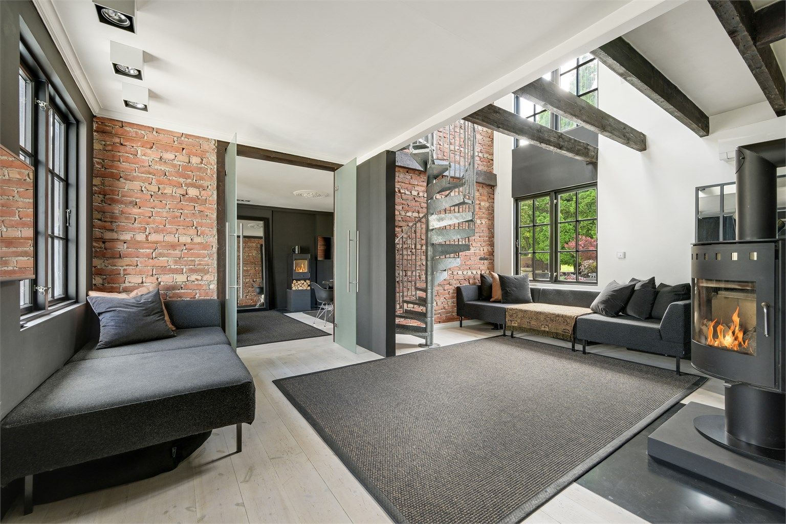 Trapp til 2. etasje er spesialbestilt industritrapp fra Risør aluminium. Rustikt med original mursteinsvegg. Fotograf: Kristian Bollæren / Fotofinish AS.