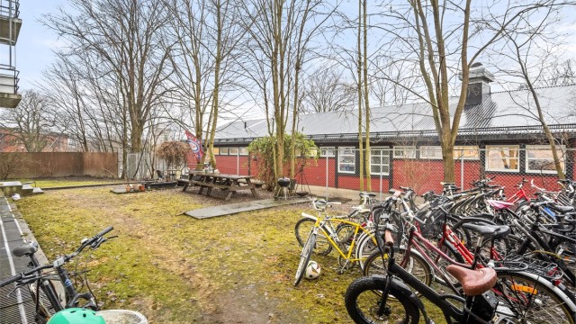 Borettslagets bakgård med sittebenker og sykkelparkering.
