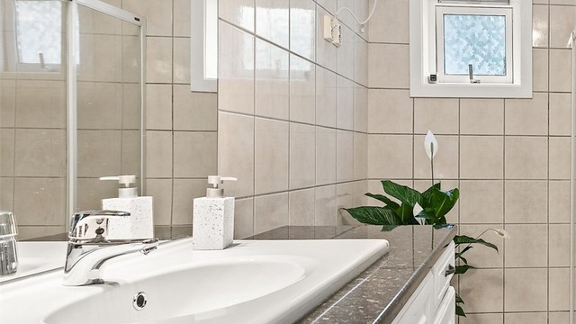 Badet har vegghengt servant med ovenpåliggende servant og ett-greps armatur. Her er det også opplegg for vaskemaskin.