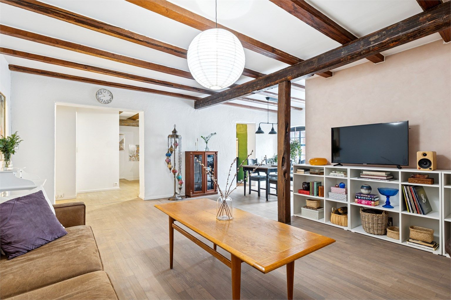 Den generøse takhøyden, synlige tredragere og detaljer i tegl gir boligen et røft og moderne uttrykk, samtidig som bygårdens opprinnelige karakter er bevart.