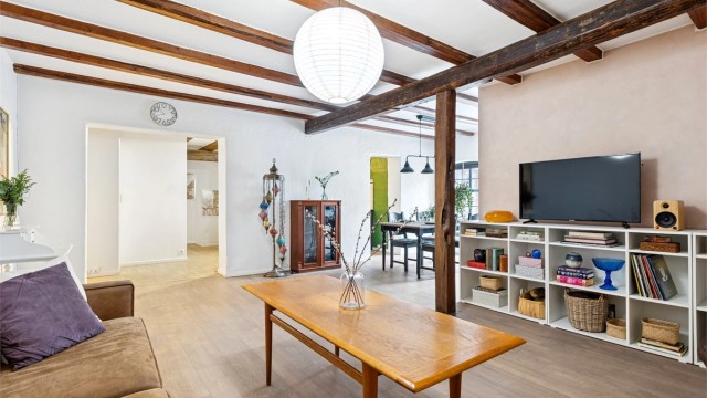 Den generøse takhøyden, synlige tredragere og detaljer i tegl gir boligen et røft og moderne uttrykk, samtidig som bygårdens opprinnelige karakter er bevart.
