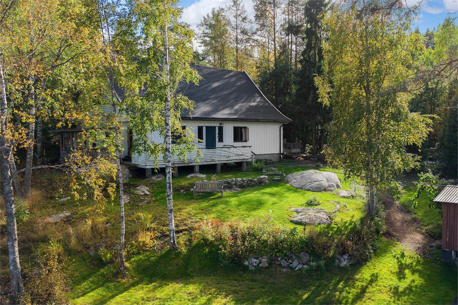Eiendommen har store, grønne utearealer og naturlige svaberg rundt boligen.