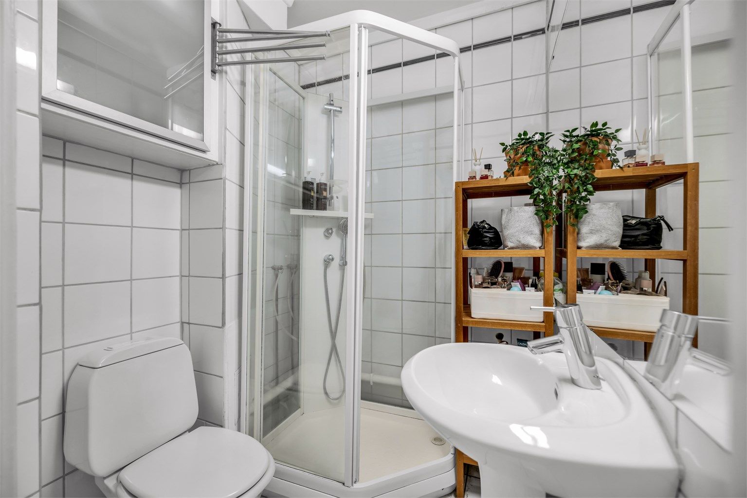 Badet er innredet med servant montert på sokkel og speil over servant.