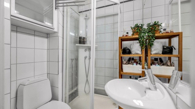 Badet er innredet med servant montert på sokkel og speil over servant.