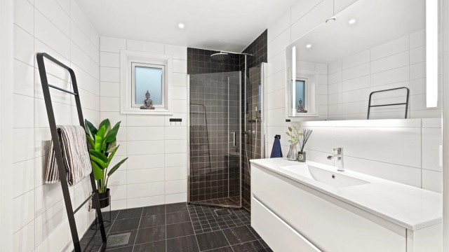 Badet i andre etasje har flislagte overflater på gulv og vegger, samt varmekabler i gulv