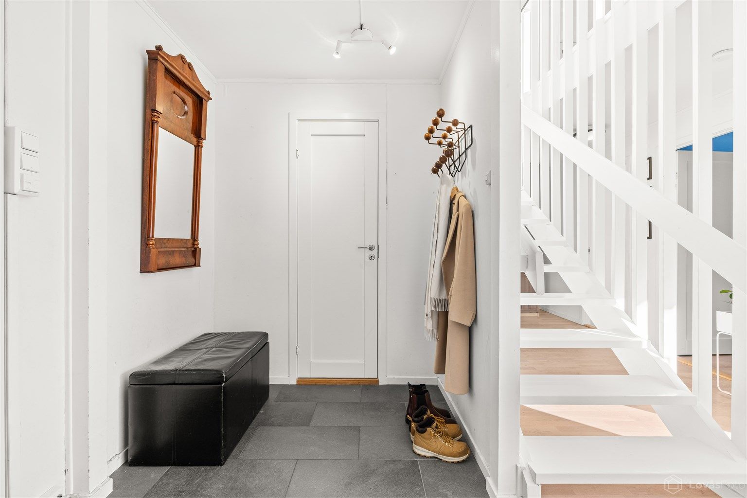 Velkommen inn i en praktisk entré med flislagt gulv og behagelig gulvvarme.