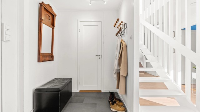 Velkommen inn i en praktisk entré med flislagt gulv og behagelig gulvvarme.
