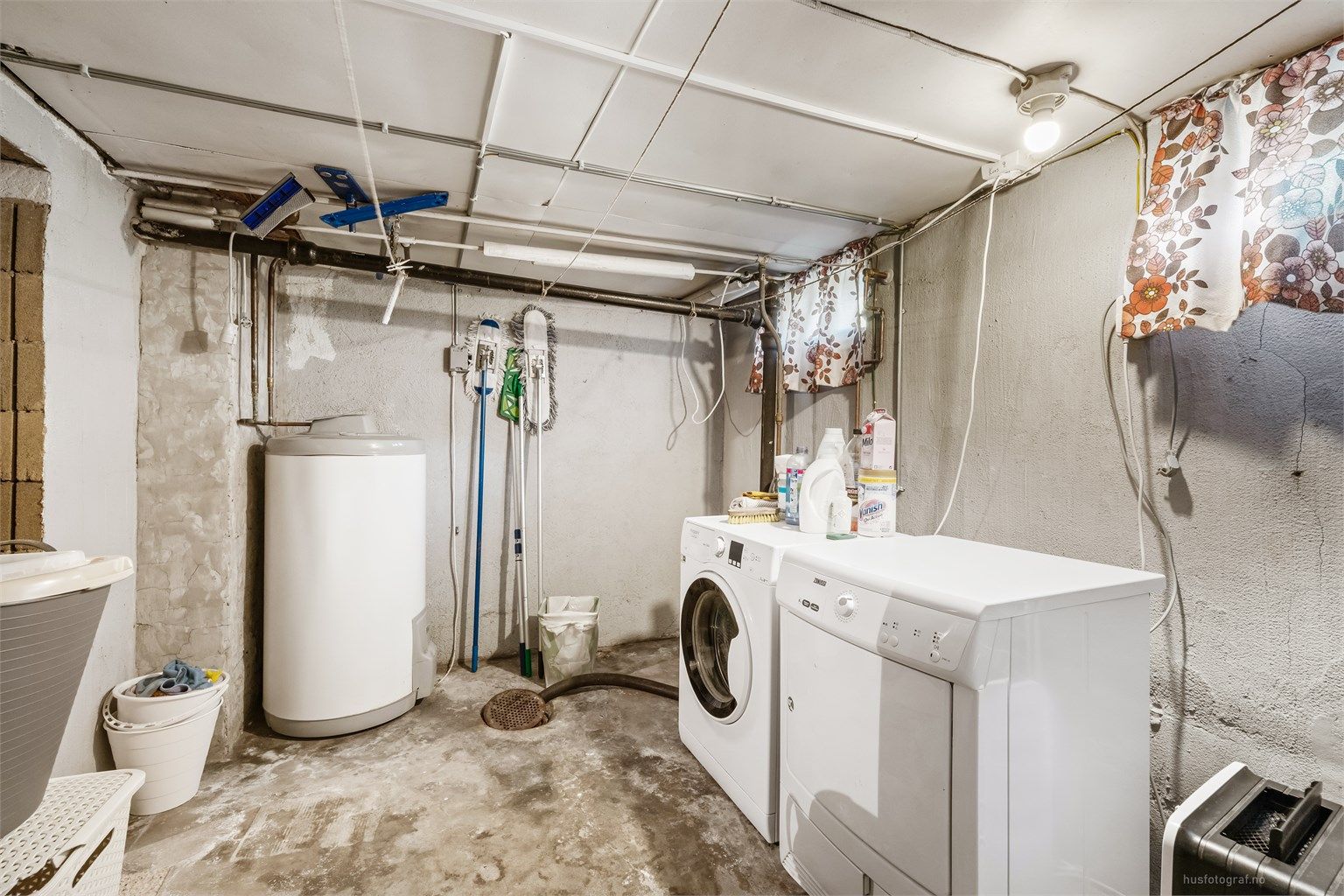 Praktisk vaskerom i kjelleren med opplegg for vaskemaskin og en 200L varmtvannsbereder.