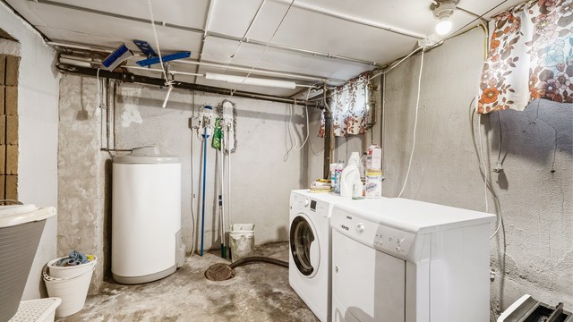Praktisk vaskerom i kjelleren med opplegg for vaskemaskin og en 200L varmtvannsbereder.
