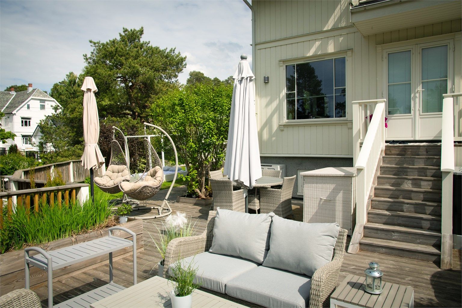 Fra stuen er det utgang til en stor terrasse belagt med terrassebord, med trapp ned til hagen.