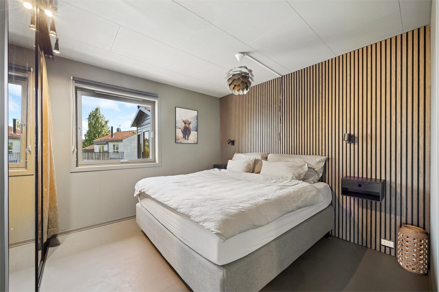 Den dekorative spileveggen tilfører rommet et moderne og eksklusivt uttrykk, og skaper en lun hotellfølelse.