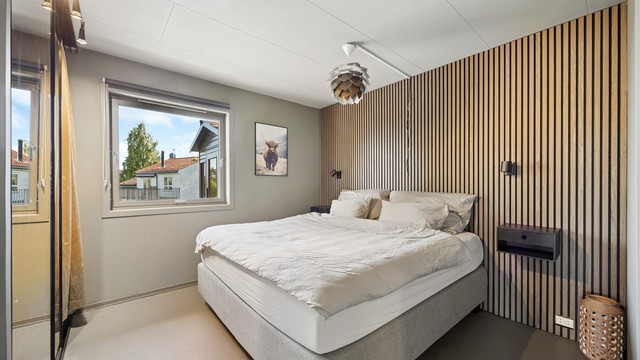 Den dekorative spileveggen tilfører rommet et moderne og eksklusivt uttrykk, og skaper en lun hotellfølelse.