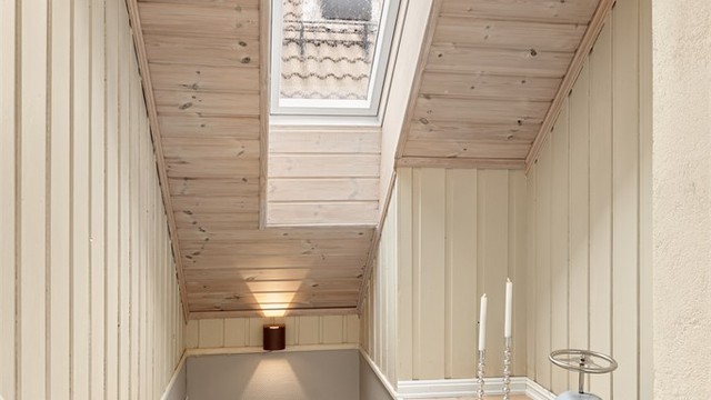 Trappeløp med panelte vegger og takvindu som slipper inn rikelig med dagslys.