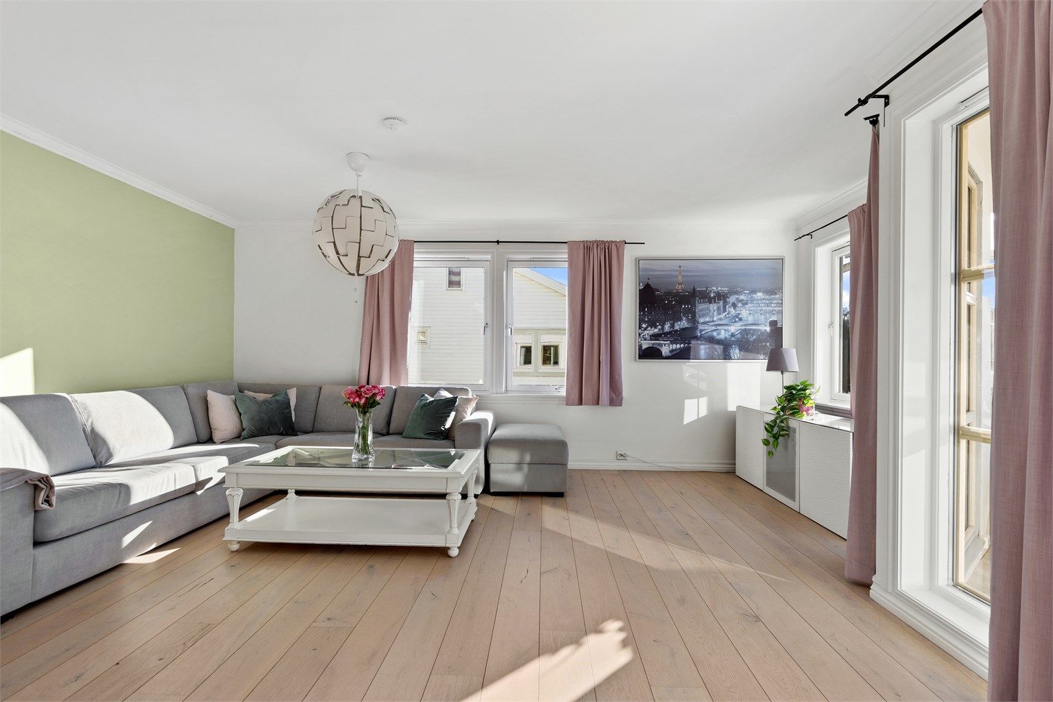 Stuen har parkett på gulvet og god plass til en stor sofagruppe. Store vindusflater sikrer rikelig med naturlig lys.