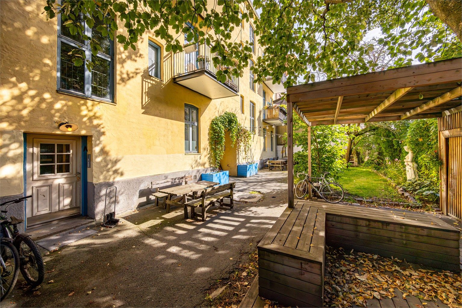 Bakgården er pent opparbeidet med blant annet terrasse på terreng, grillplass, sittegrupper og hønsehus.