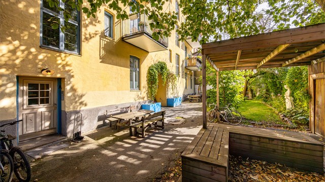 Bakgården er pent opparbeidet med blant annet terrasse på terreng, grillplass, sittegrupper og hønsehus.