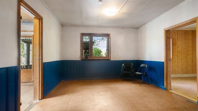 Romslig stue i 1. etasje med brystningspanel og vindu mot hagen.