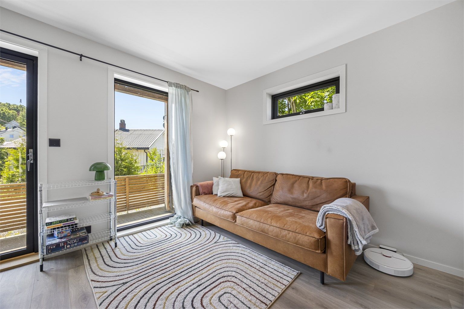 Gjennomgående laminat på gulv og malte plater på vegger gir et helhetlig og stilrent uttrykk.