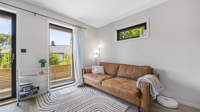 Gjennomgående laminat på gulv og malte plater på vegger gir et helhetlig og stilrent uttrykk.