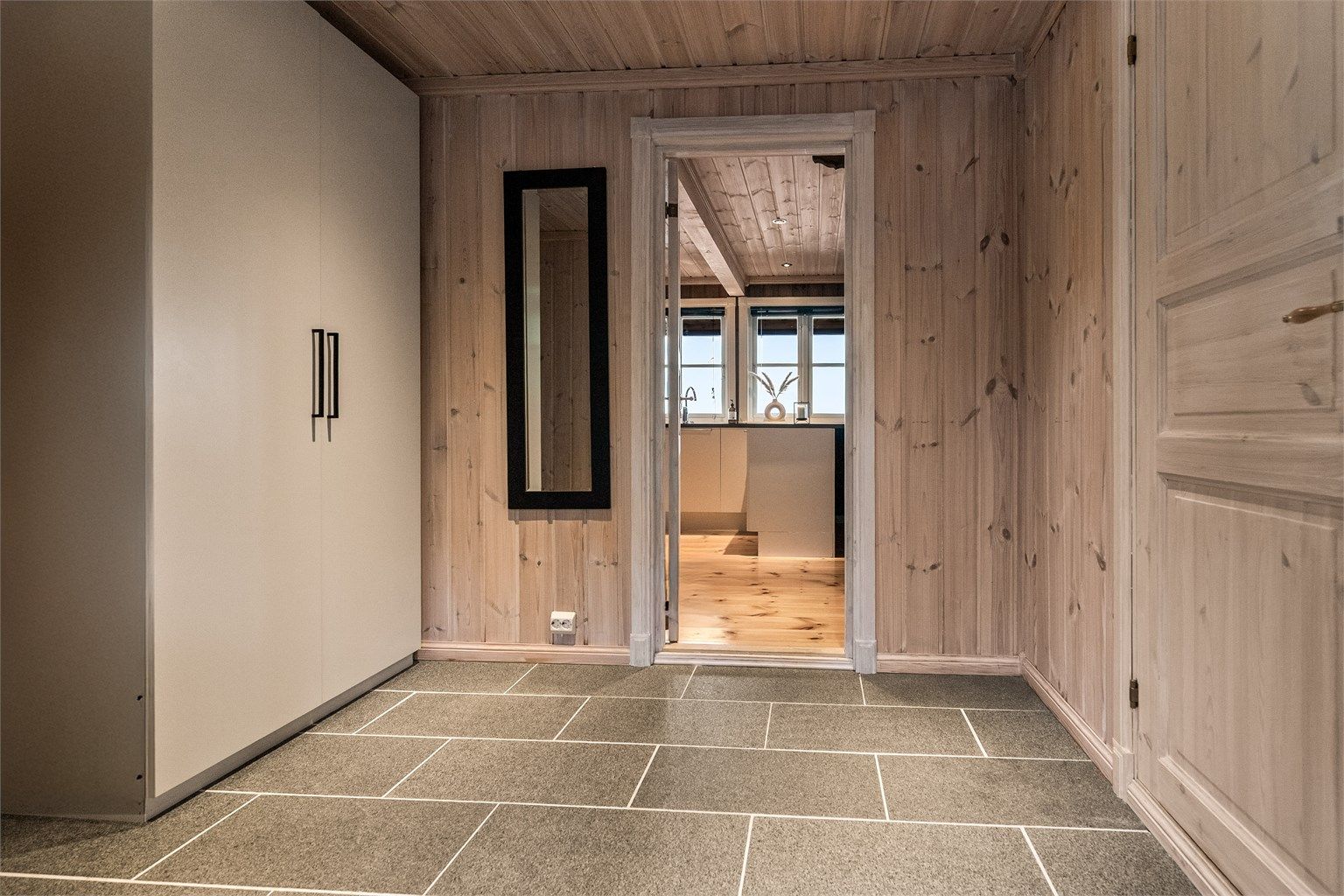 Stor hall med garderobe, tilliggende bod og praktisk med flislagte gulv