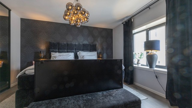 Hovedsoverommet fremstår som romslig og innbydende, med god plass til dobbeltseng og et tilhørende walk-in-closet som sørger for rikelig med oppbevaringsplass.