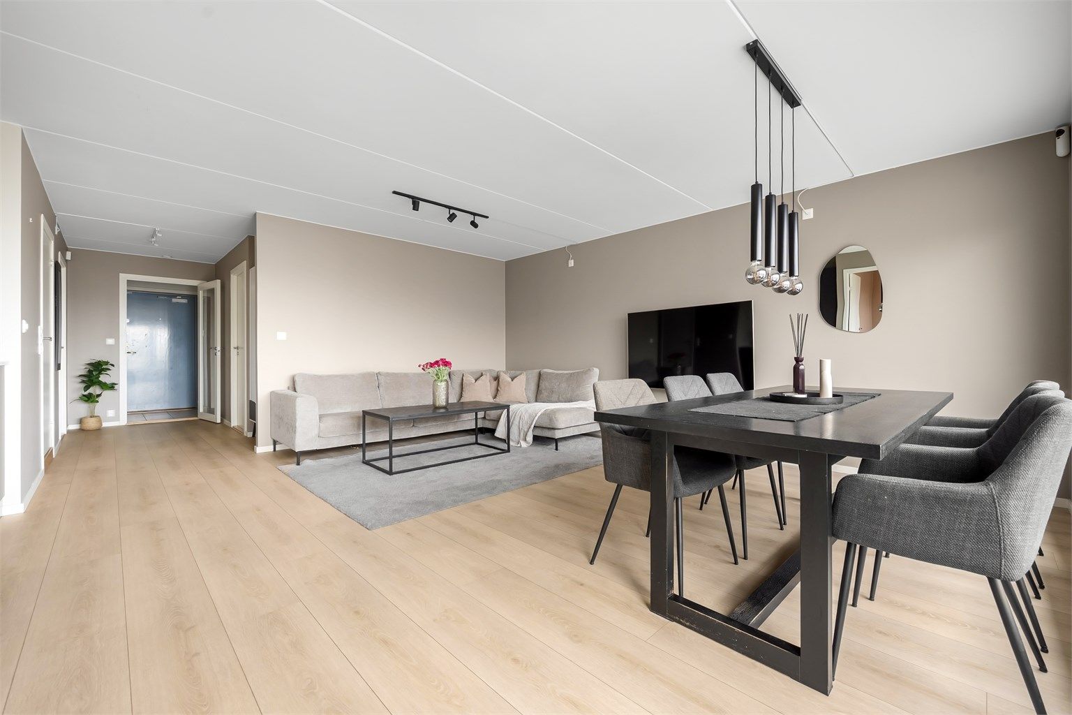 Stuen er et lyst og åpent rom med god plass til både sofagruppe og spisebord. Gulvet er belagt med laminat.