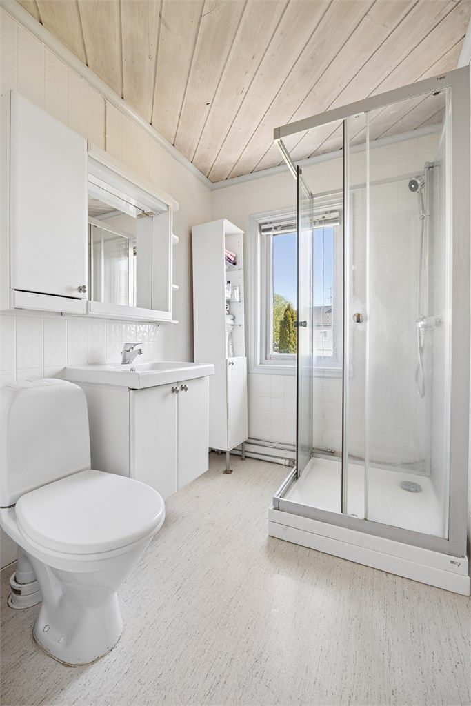 Videre er badet innredet med dusjkabinett og gulvstående toalett.