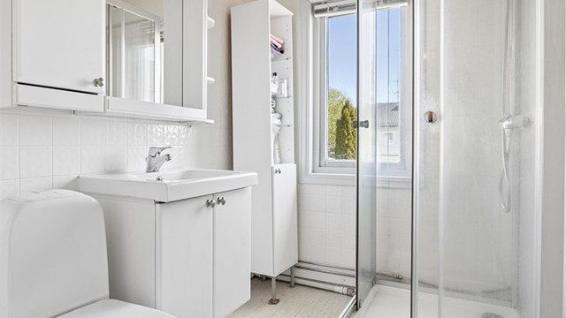 Videre er badet innredet med dusjkabinett og gulvstående toalett.