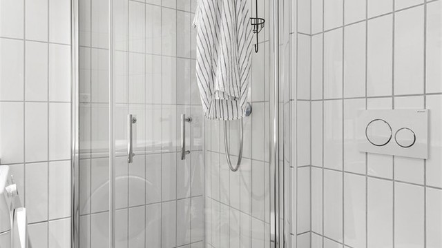 Baderommet er innredet med vegghengt servant, speilskap, dusjhjørne, vegghengt toalett og opplegg for vaskemaskin.