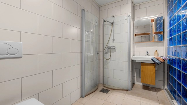 Bad i underetasjen på 4,5 kvm med flislagte overflater, gulvvarme og praktisk planløsning.