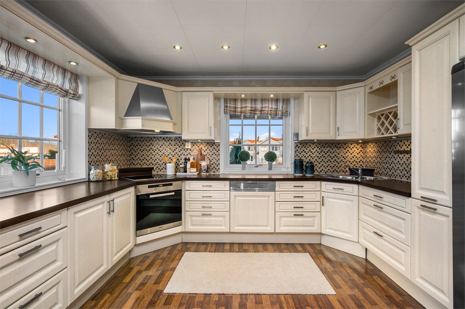 Kjøkkenet har utstrakt bruk av downlights og integrert stekeovn, platetopp, kaffemaskin, oppvaskmaskin og mikrobølgeovn. Frittstående kjøleskap og fryseskap.