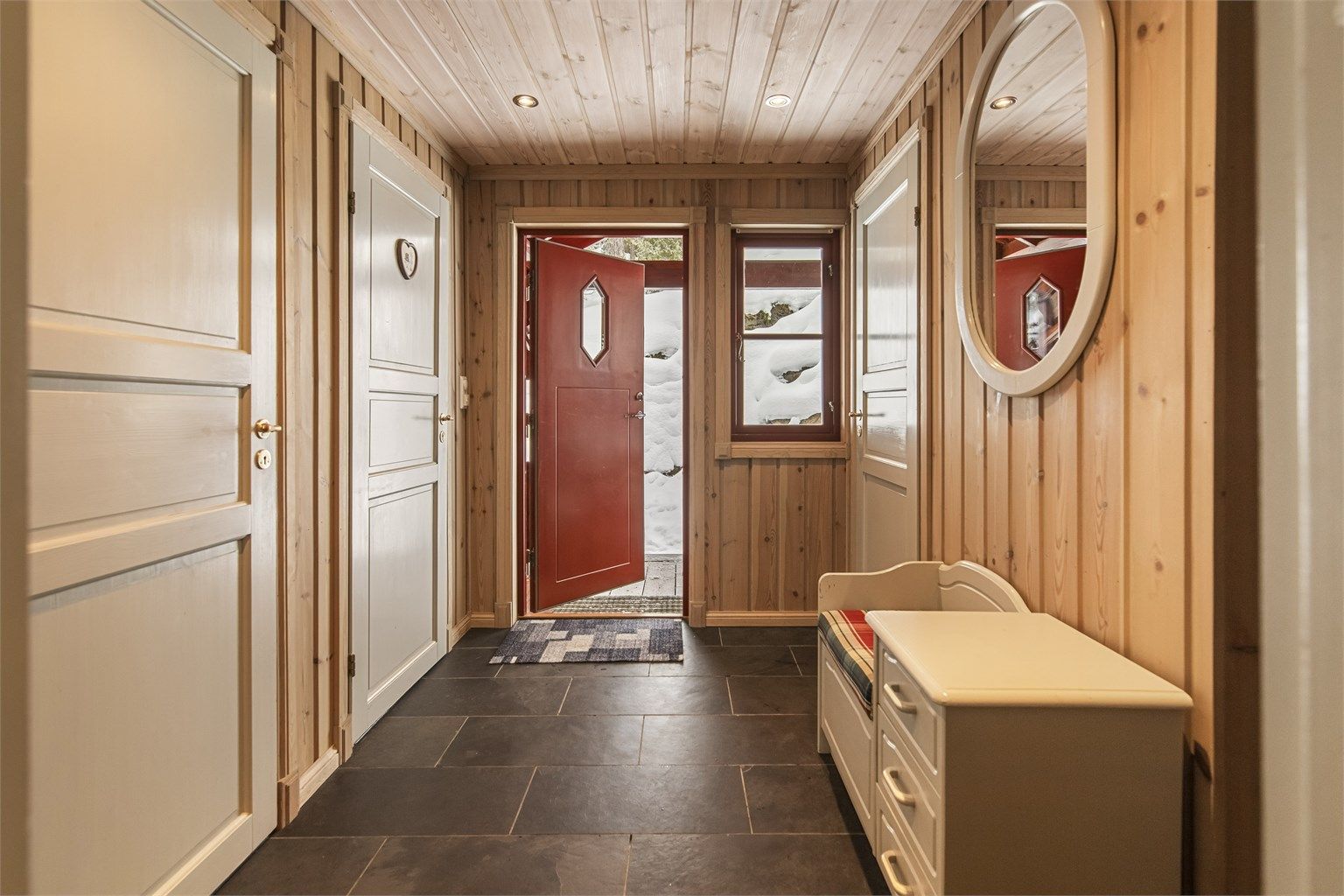 Entréen har flislagt gulv og gir tilgang til bad, toalettrom og en praktisk innvendig bod.
