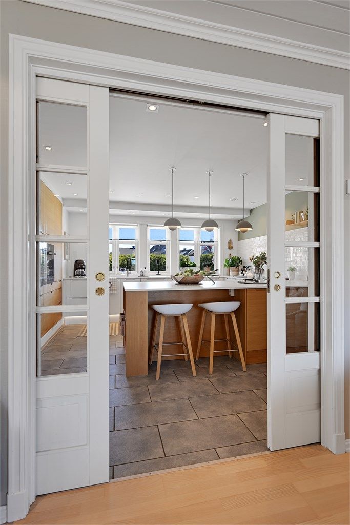 Dobbel skyvedør med glassfront skiller kjøkken og tv stue. 