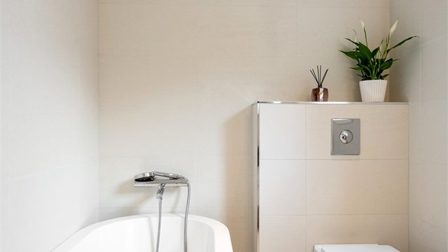 Et vegghengt toalett og delikate materialvalg gir et rent og ryddig uttrykk på badet