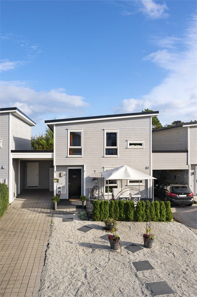 Inngangspartiet har tilhørende carport, utvendig bod og en treplatting i front.