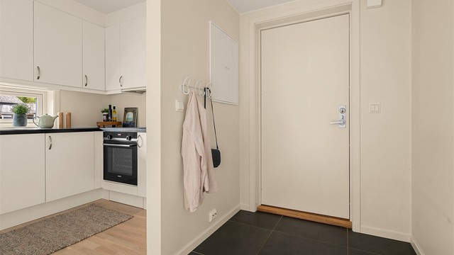 Entré med flislagt gulv, praktisk plass til yttertøy og enkel adkomst videre inn i boligen.