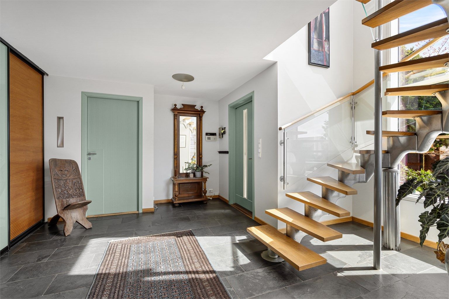 Romslig og åpen entré og hall med skifer på gulv, varmekabler og romslig skyvedørsgarderobe. 