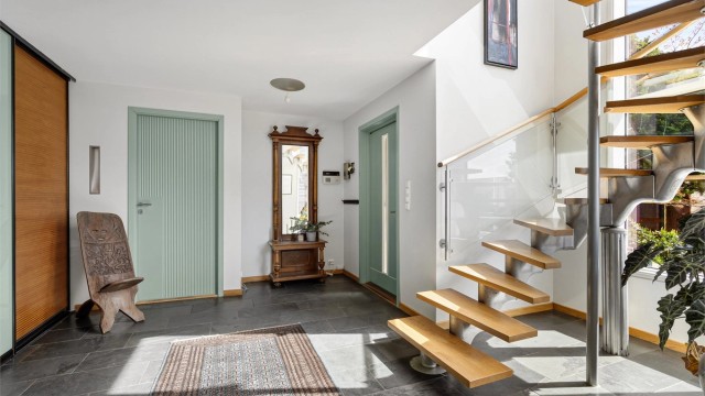 Romslig og åpen entré og hall med skifer på gulv, varmekabler og romslig skyvedørsgarderobe.