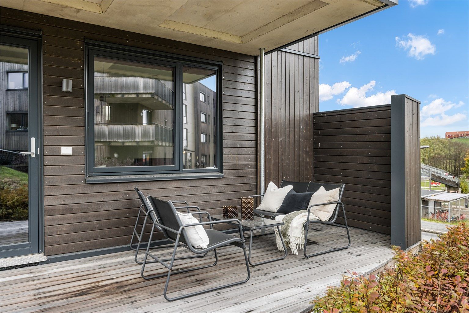 Skjermet uteplass med utvendig belysning og stikkontakt på fasaden.