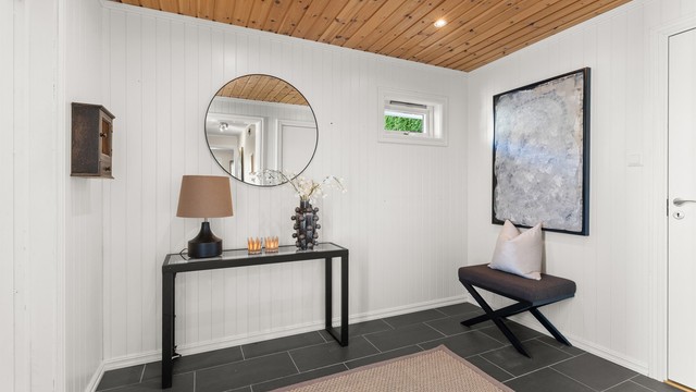 Innbydende entré med flislagt gulv og gulvvarme. Entréen har god plass til garderobeløsning, enten i form av garderobeskap eller skyvedørsgarderobe, og gir et praktisk førsteinntrykk av boligen.