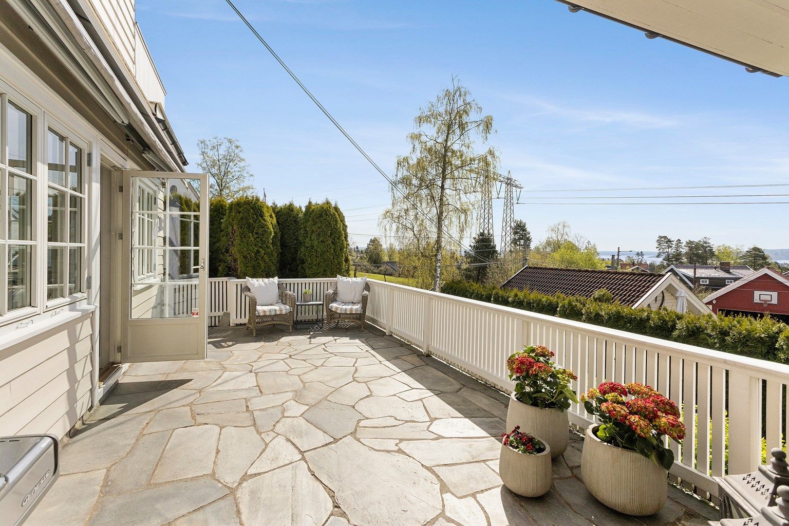 Utgang fra stue til steinbelagt og delvis overbygget veranda på ca. 36 kvm. Overbygget er fra 2005. 