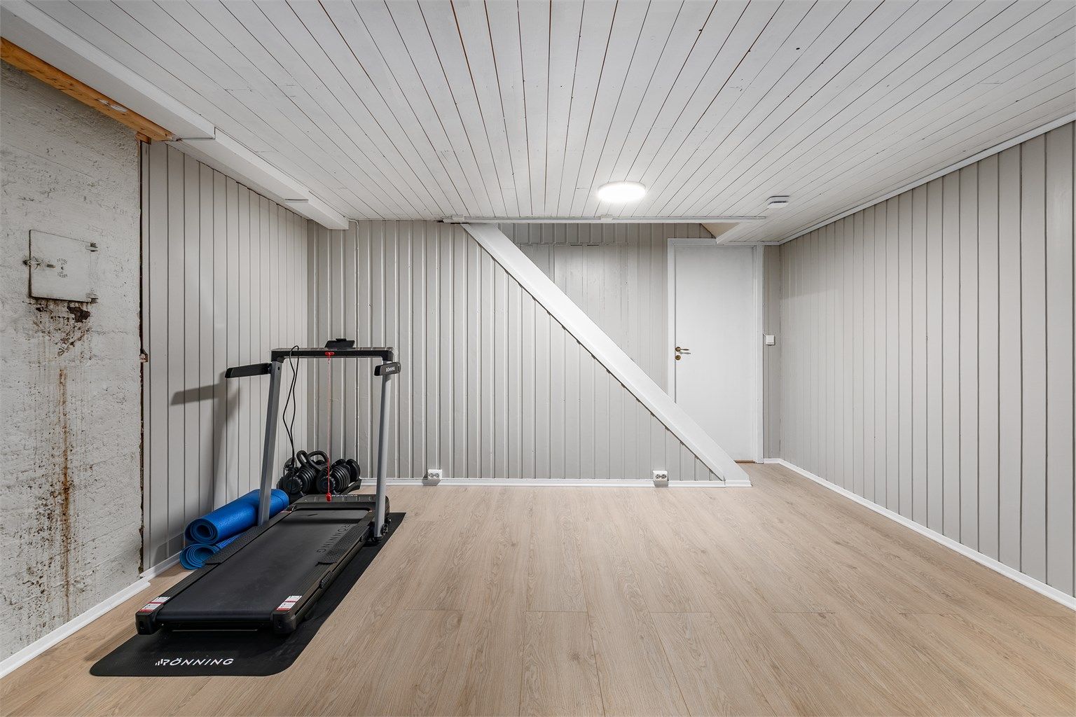 Dette over 20 kvm. store kjellerrommet er nylig pusset opp. På gulvet er det lagt laminat, panel på vegger og himling er malt.