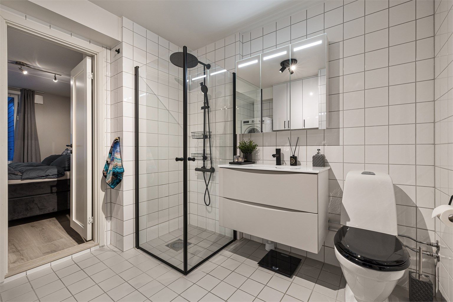 Badet har en moderne innredning fra Epoq og en romslig dusjnisje.