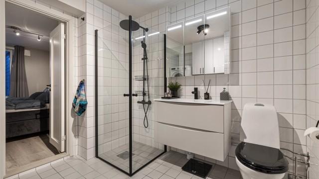 Badet har en moderne innredning fra Epoq og en romslig dusjnisje.