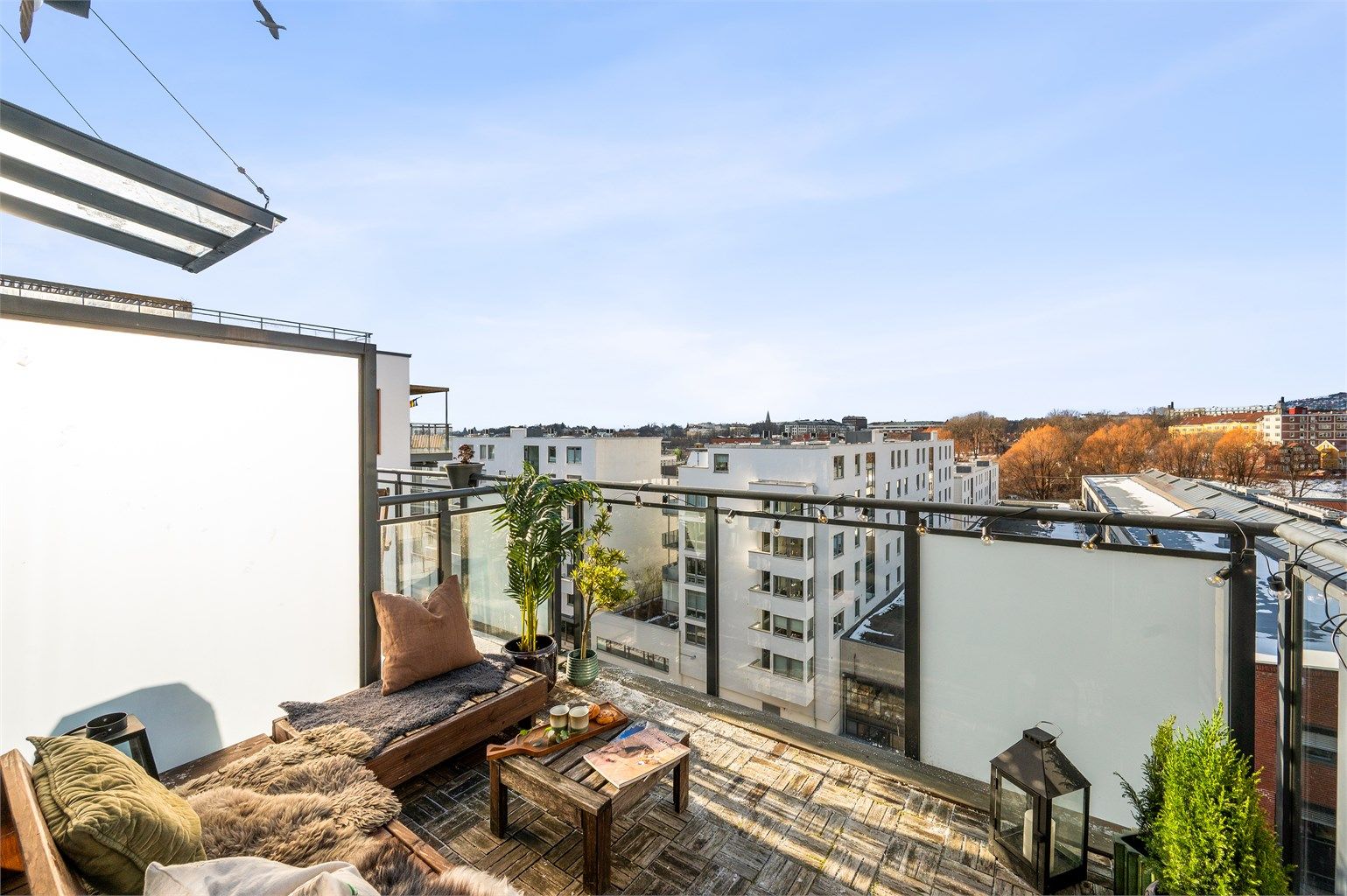Balkongen er åpen mot himmelen uten overbygg, noe som gir en privat og luftig følelse.